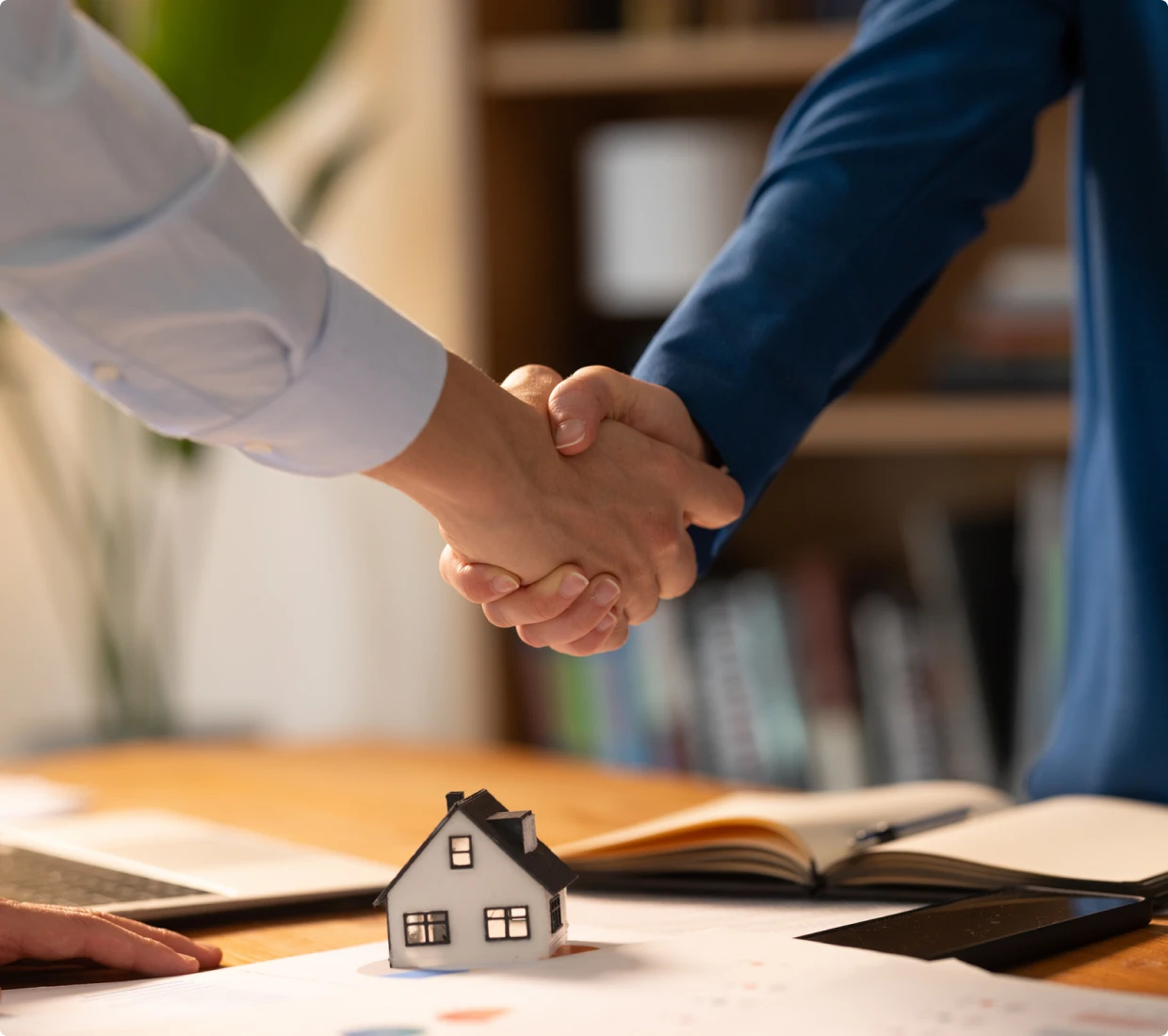 Business agreement with house model on table